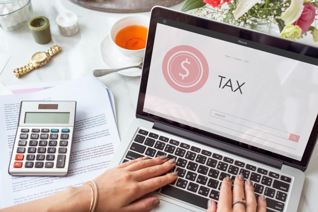 Laptop, calculator, and tax filing documents on a desk