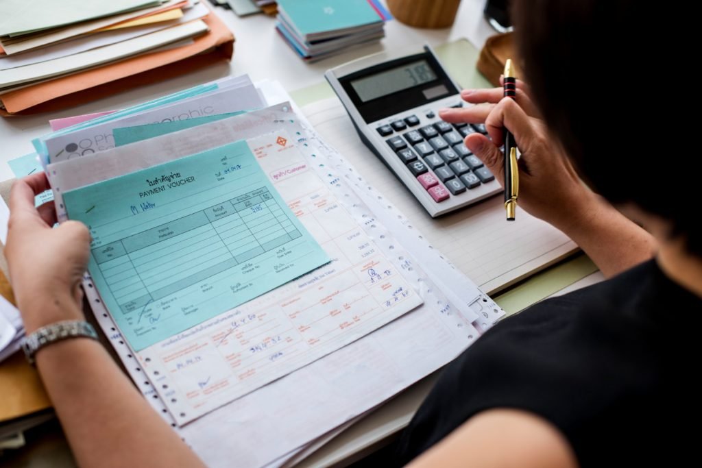 Tax documents, receipts, and a calculator prepared for review